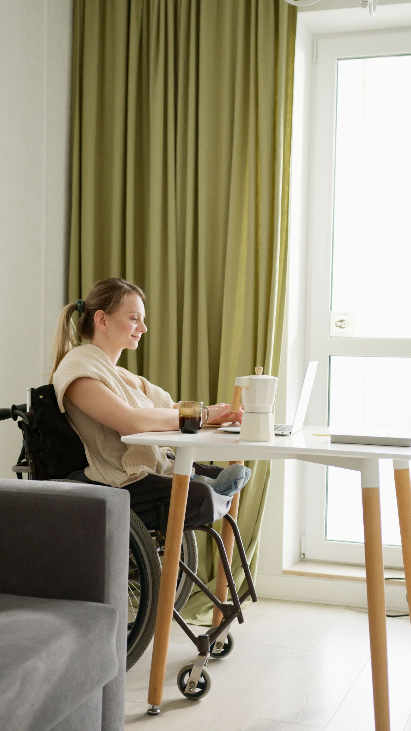 A woman in a wheelchair working at her desk at home